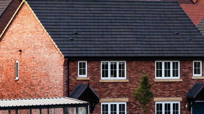 exterior of red brick house with black roof