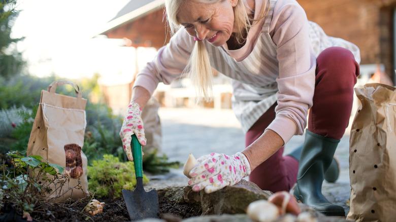 older woman planting flower bulbs