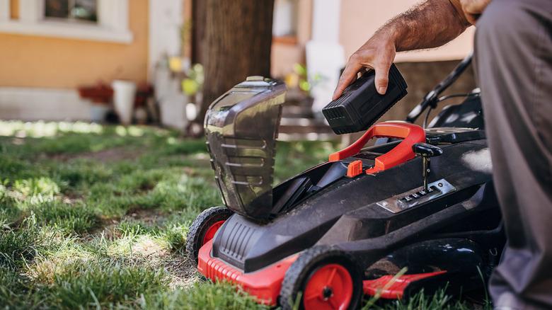 Man putting battery in mower