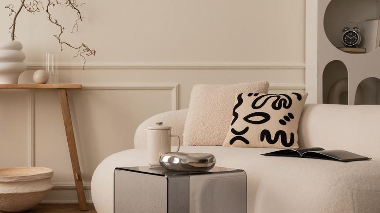living room with beige walls, beige sofa, and beige, wood, and black accents