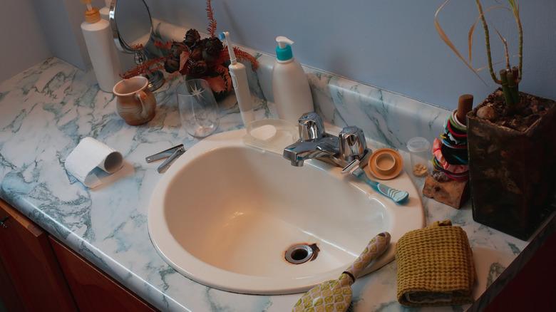 bathroom counter cluttered with bathroom essentials