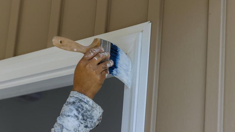 close up of hand painting door and door trim