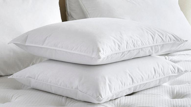 two pillows stacked on top of a bed