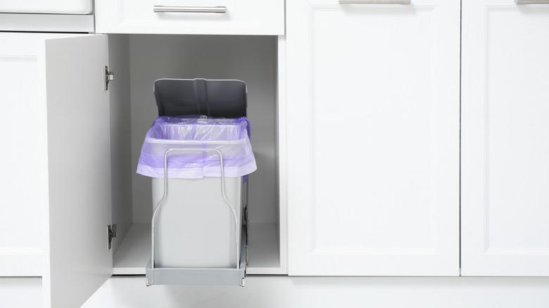 open white cabinet with pull-out trash cans with integrated lid