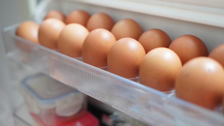 A close-up image of eggs filling a refrigerator plastic container