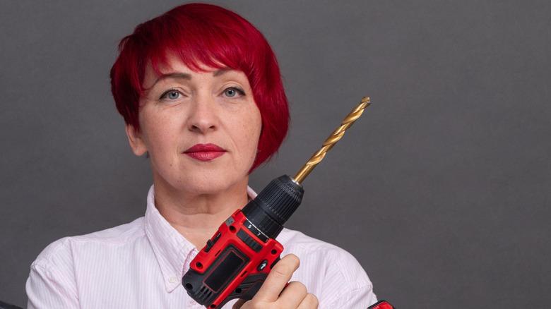 Woman hold cordless drill with large diameter bit