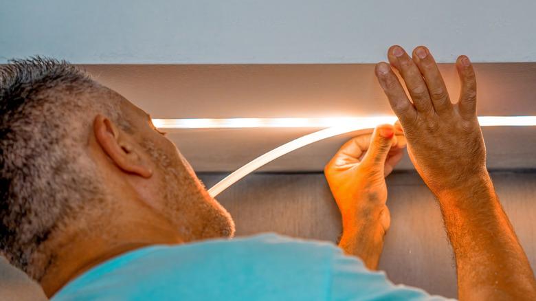man installing led light strip