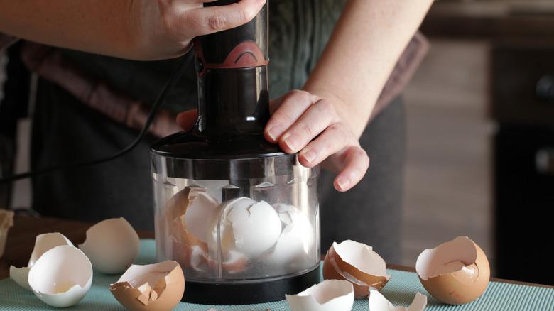 A person grinds eggshells into a powder