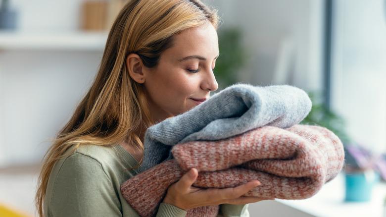 Woman smelling stack of laundry