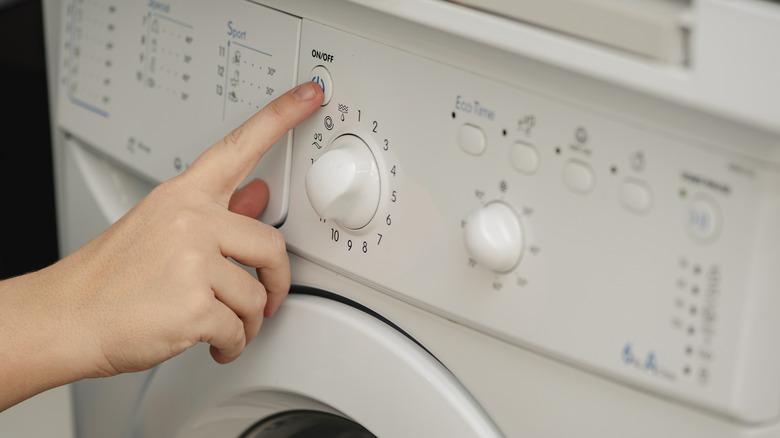 person adjusting settings on a washing machine