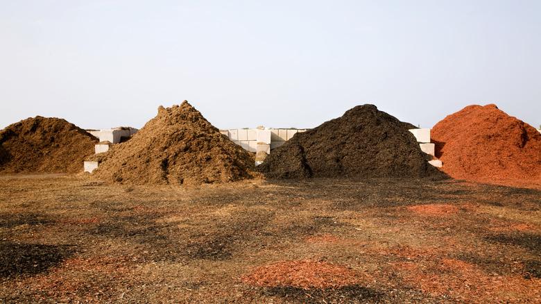 piles of different colored mulch sitting at construction site