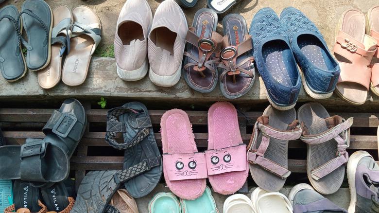 many women's shoes lined up outside in a row