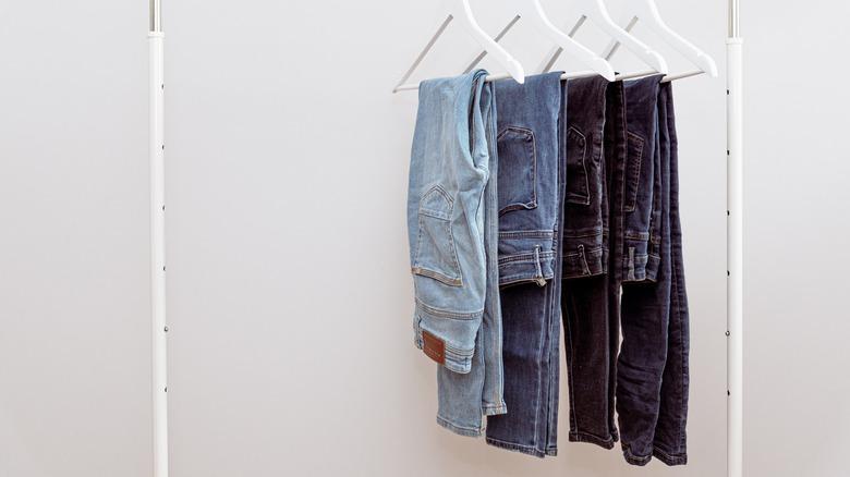 denim jeans folded over hangers