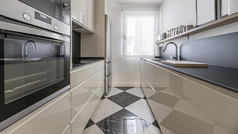 A small kitchen with black-and-white checkered porcelain tiled floors