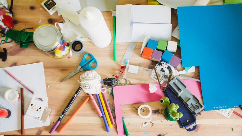 table covered with messy assortment of crafting supplies