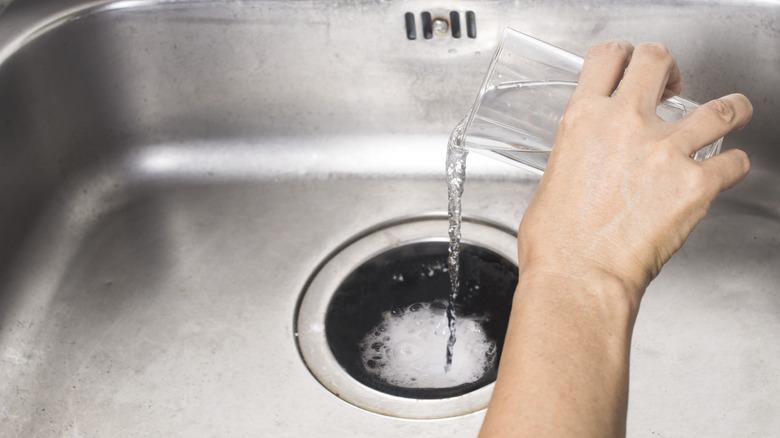 sink drain bubbling with baking soda and hydrogen peroxide being poured in