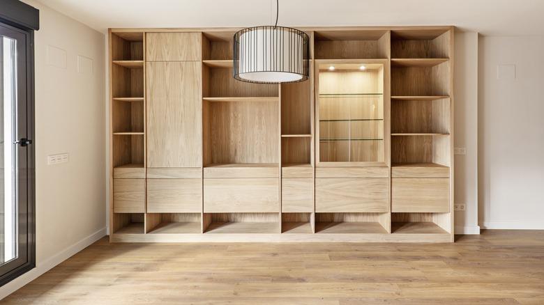 white oak flooring and white oak custom-made bookshelves visible by a sliding glass door and modernist hanging light
