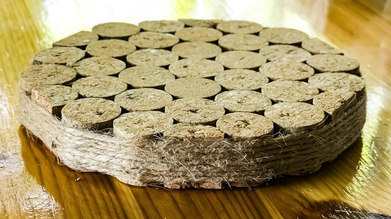 A hot pot trivet composed of wine corks wrapped with twine.