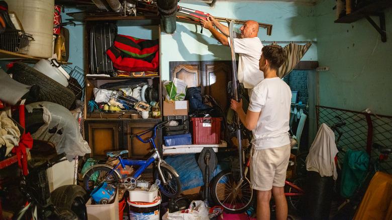 two people cleaning a messy garage