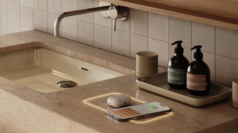 An illuminated integrated wireless charging station with a phone and earbuds