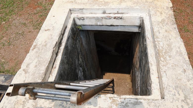 ladder leading into the concrete entrance of an underground bunker