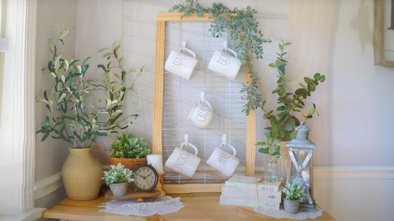 a coffee corner with potted plants and other decor and a wood frame, wire rack for hanging coffee mugs