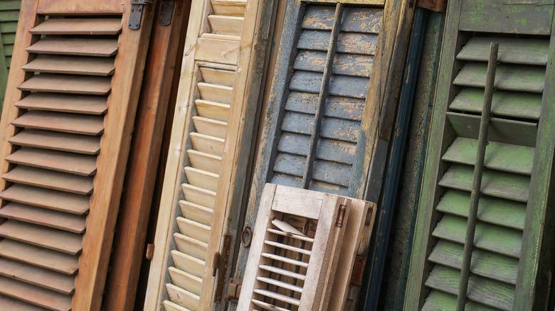 close up of a variety of different colored old window shutters