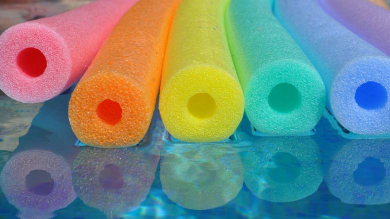 rainbow pool noodles floating in the water