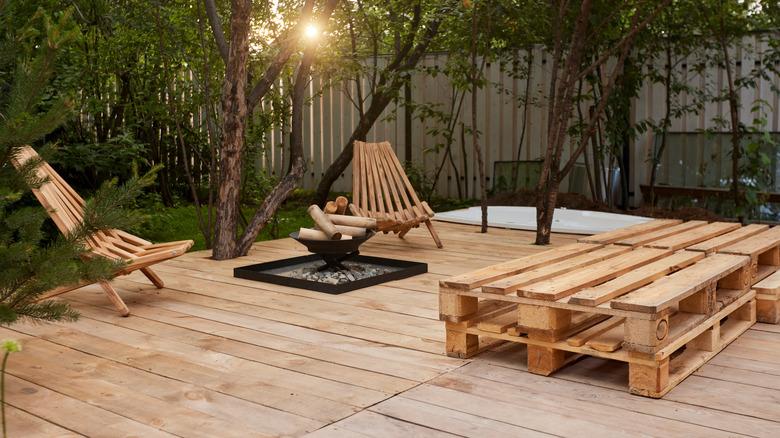 An outdoor patio spaces includes multiple stacked wood pallets.