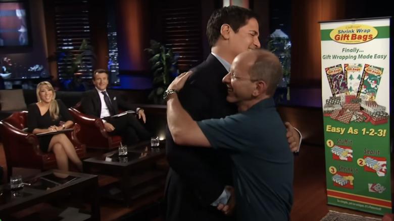 Billionaire Mark Cuban and CoolWraps inventor Jeffrey Miller embrace after making an acquisition deal on Shark Tank