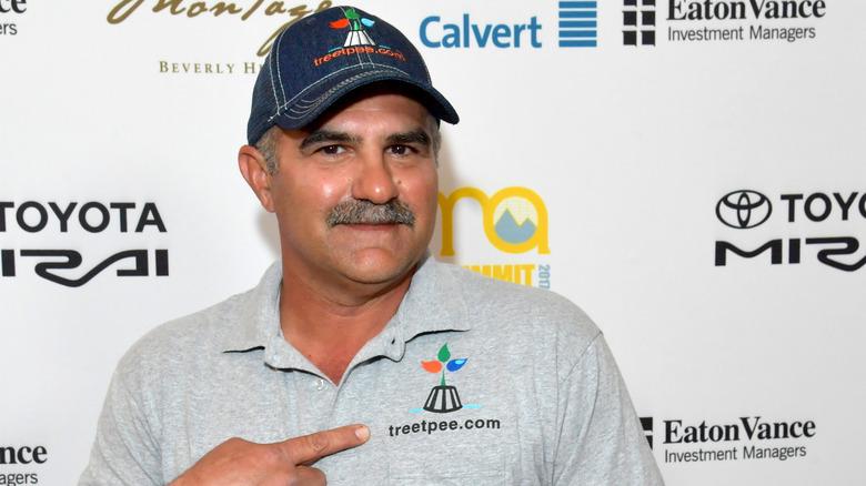 The owner of Tree T-Pee as featured on ABC's Shark Tank pointing to his company's logo on his shirt.