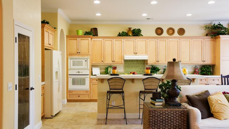 a warm kitchen with standard height cabinets that display plants and woven baskets