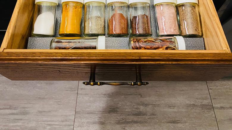 Bottles of spices laid flat in a drawer