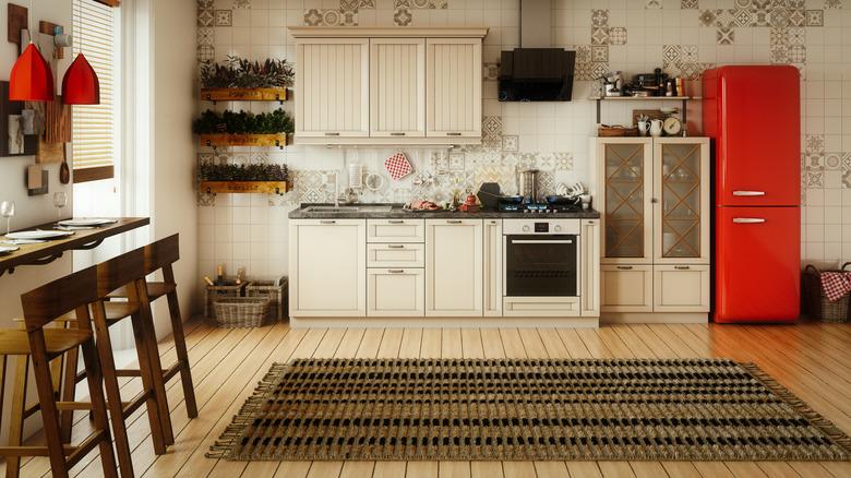 kitchen with light colored cabinets and red accessories