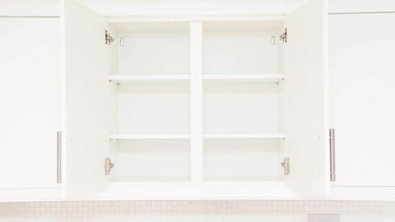 image of white upper cabinet with center divider open with nothing in it but adjustable shelves