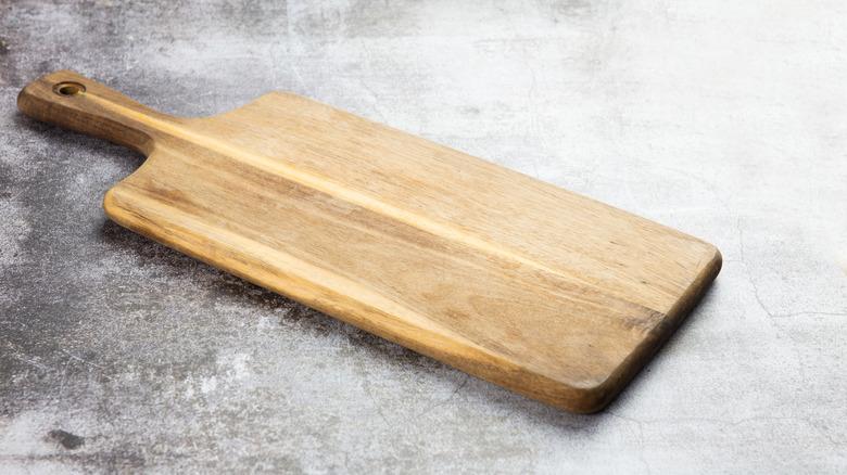 wooden cutting board on concrete or gray slab