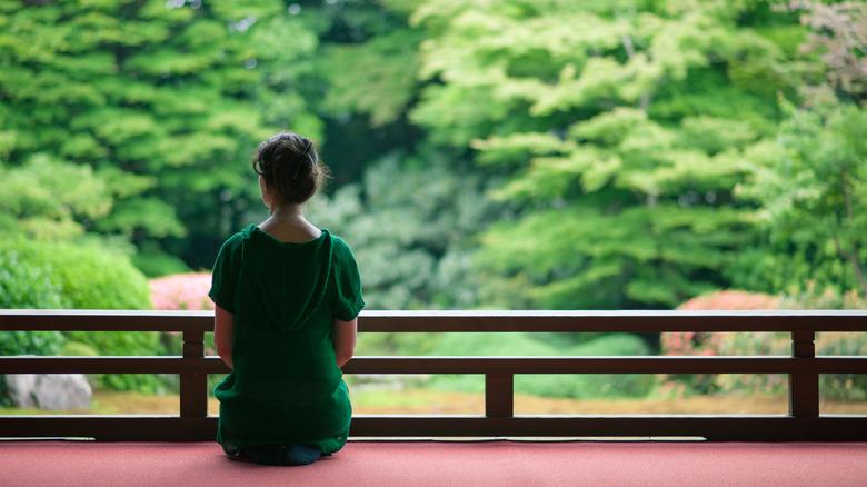 Woman looking out at garden at a Japanese Buddhist temple