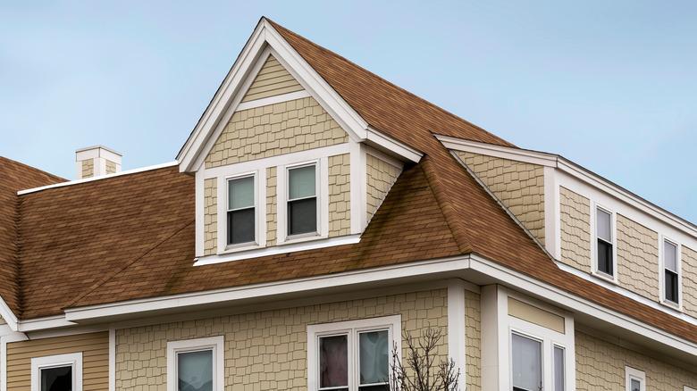 house with beige siding, white trim, and tan shingle roof